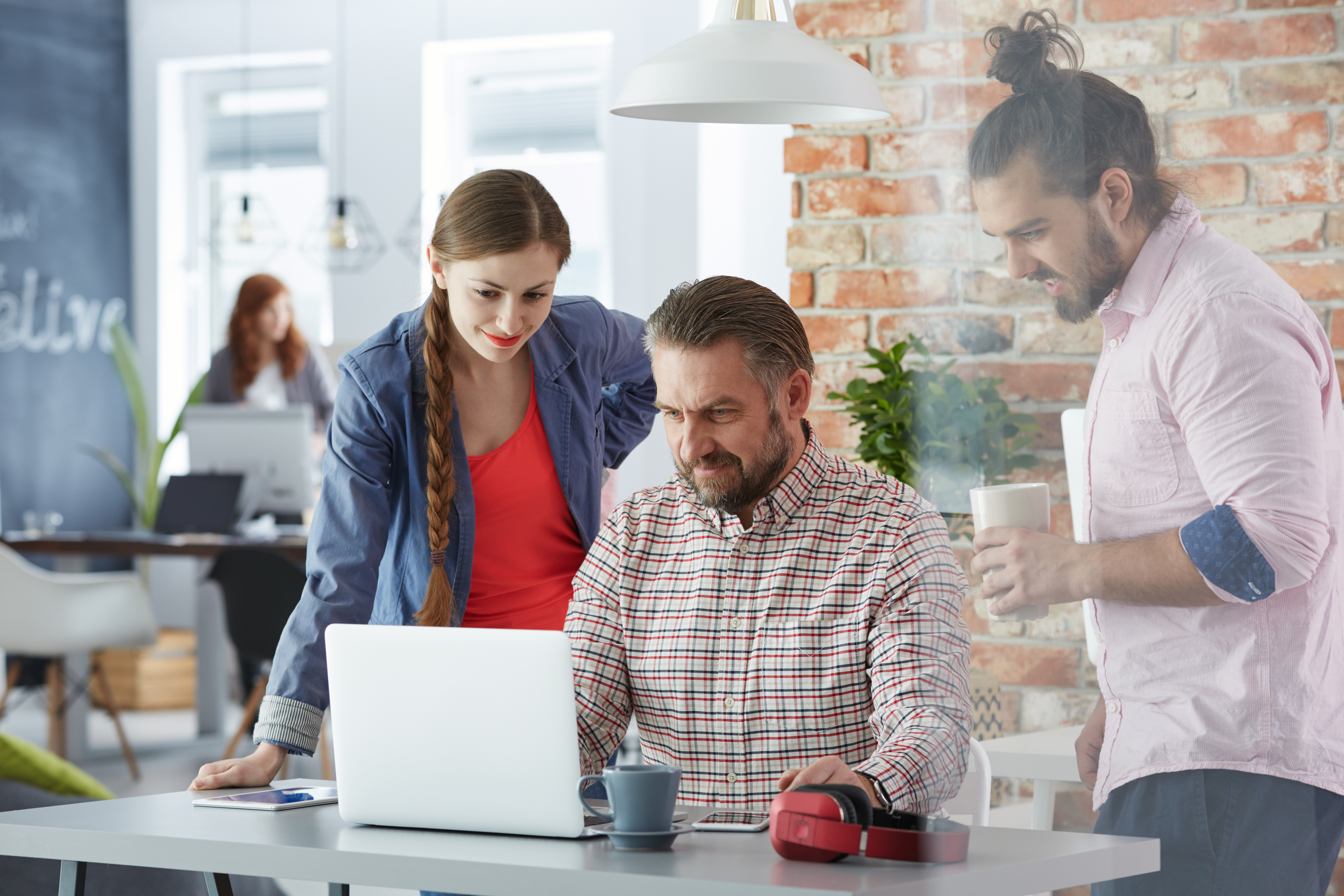 A group of marketers looking at a laptop