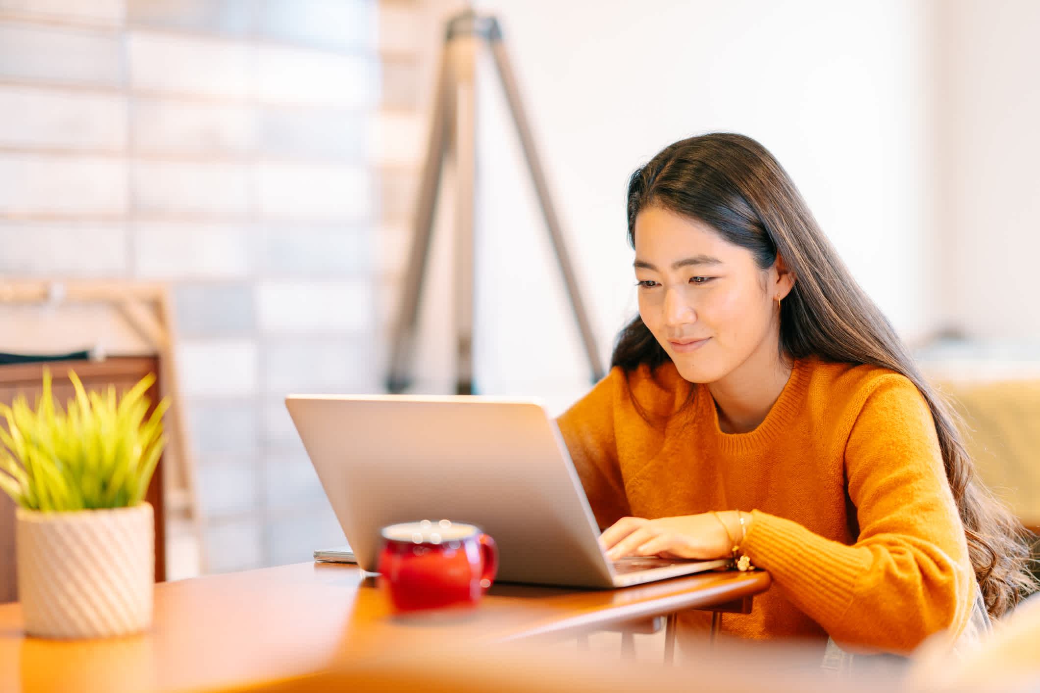 A young woman working independently as a freelancer on her laptop. | Watermark