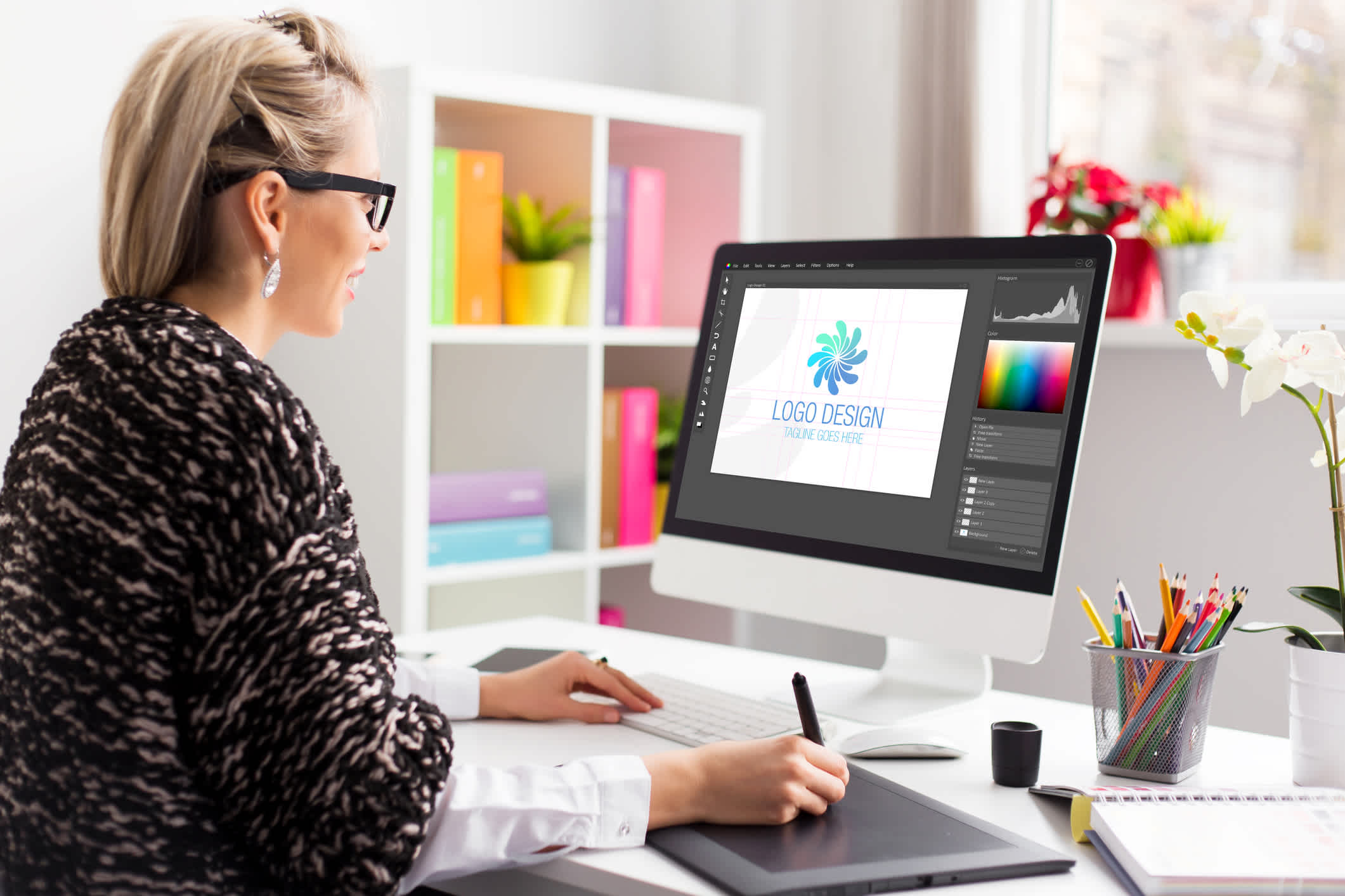 Graphic design artist working at the office on client's logo design. | Watermark
