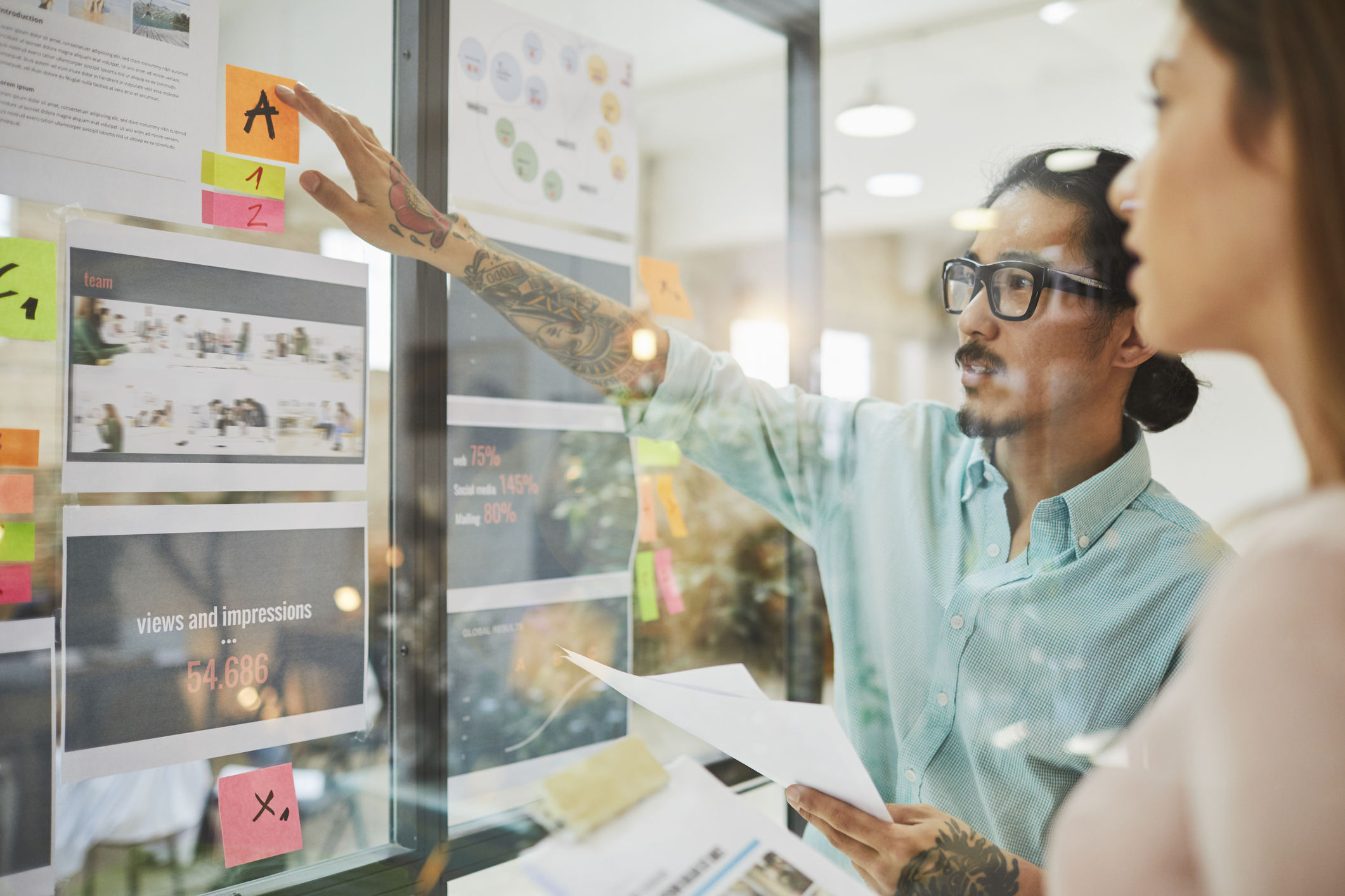 Professional male and female colleagues are brainstorming meetings in a small business office. | Watermark
