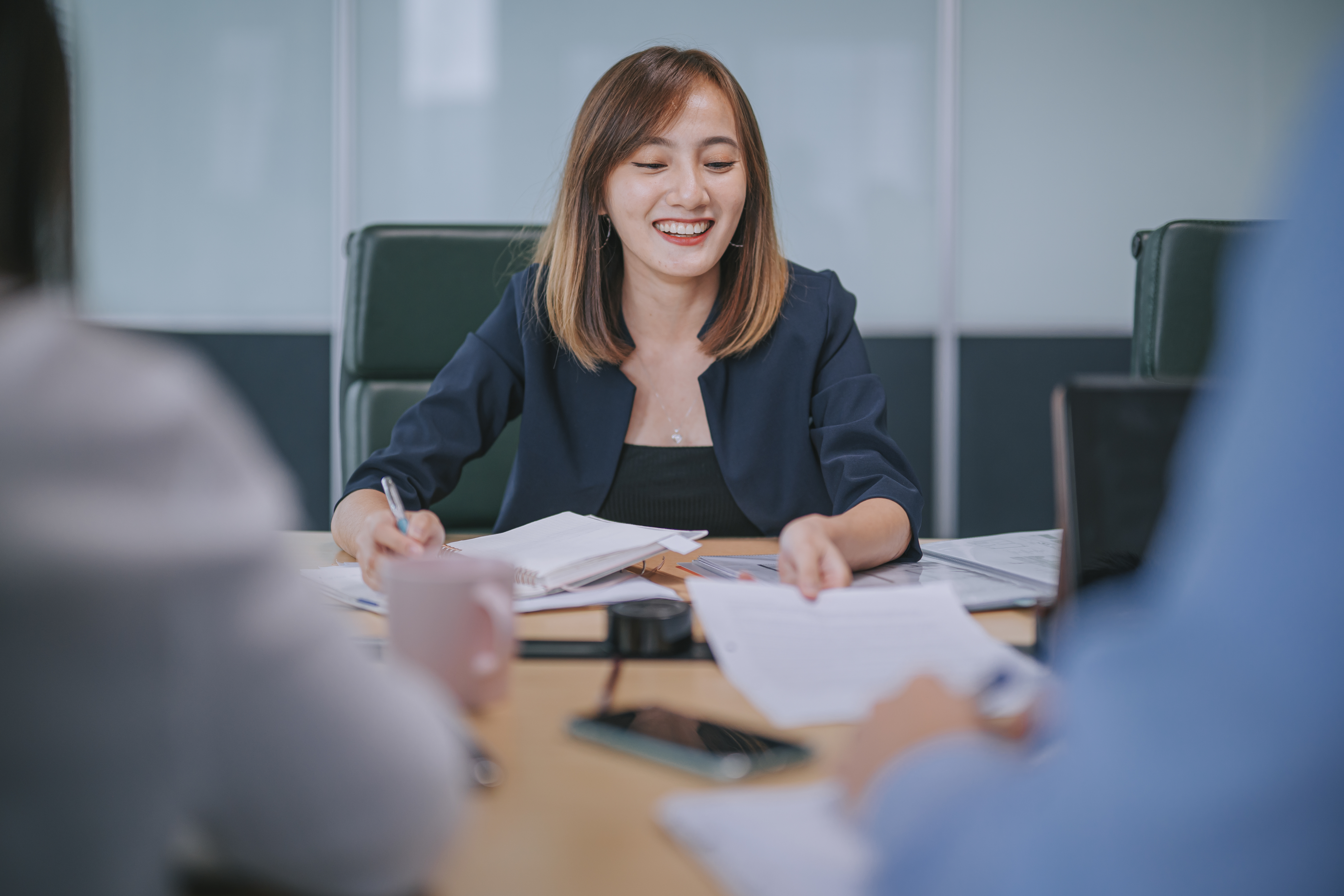 A woman smiling and discussing business matters with clients