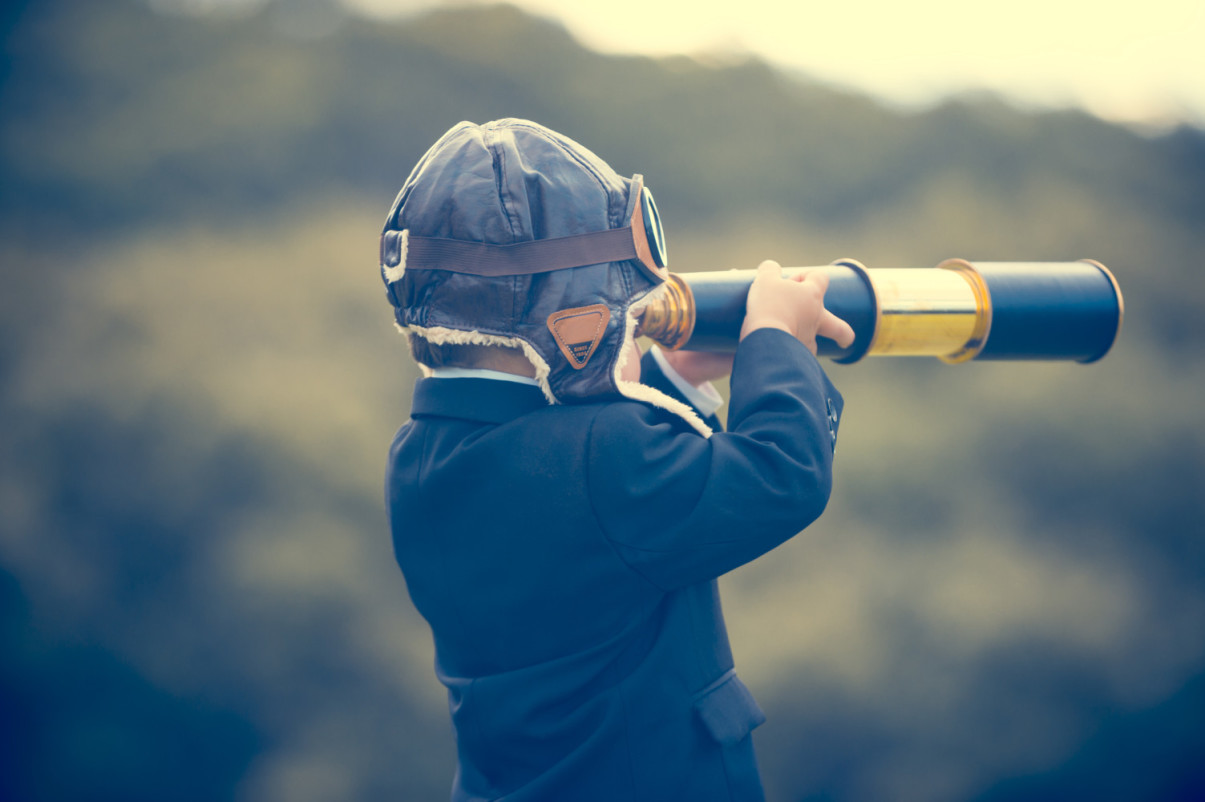 Young boy in a business suit with telescope.