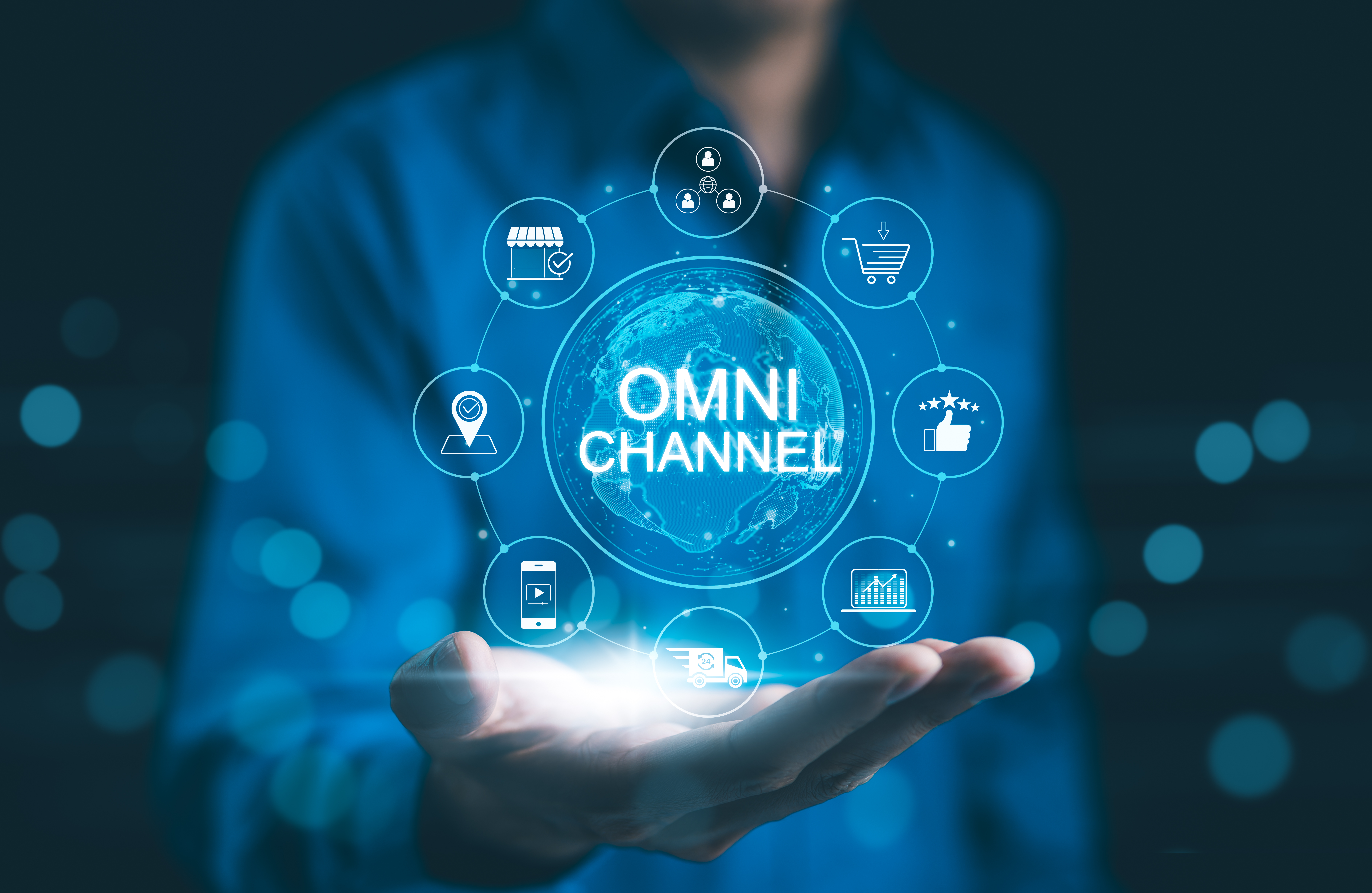 Hand holding a glowing omnichannel graphic with connected icons for mobile, location, analytics, reviews and customer network