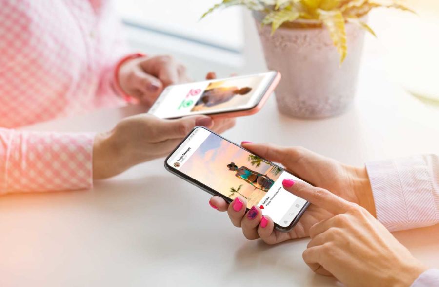 Two women using social media on their mobile phones