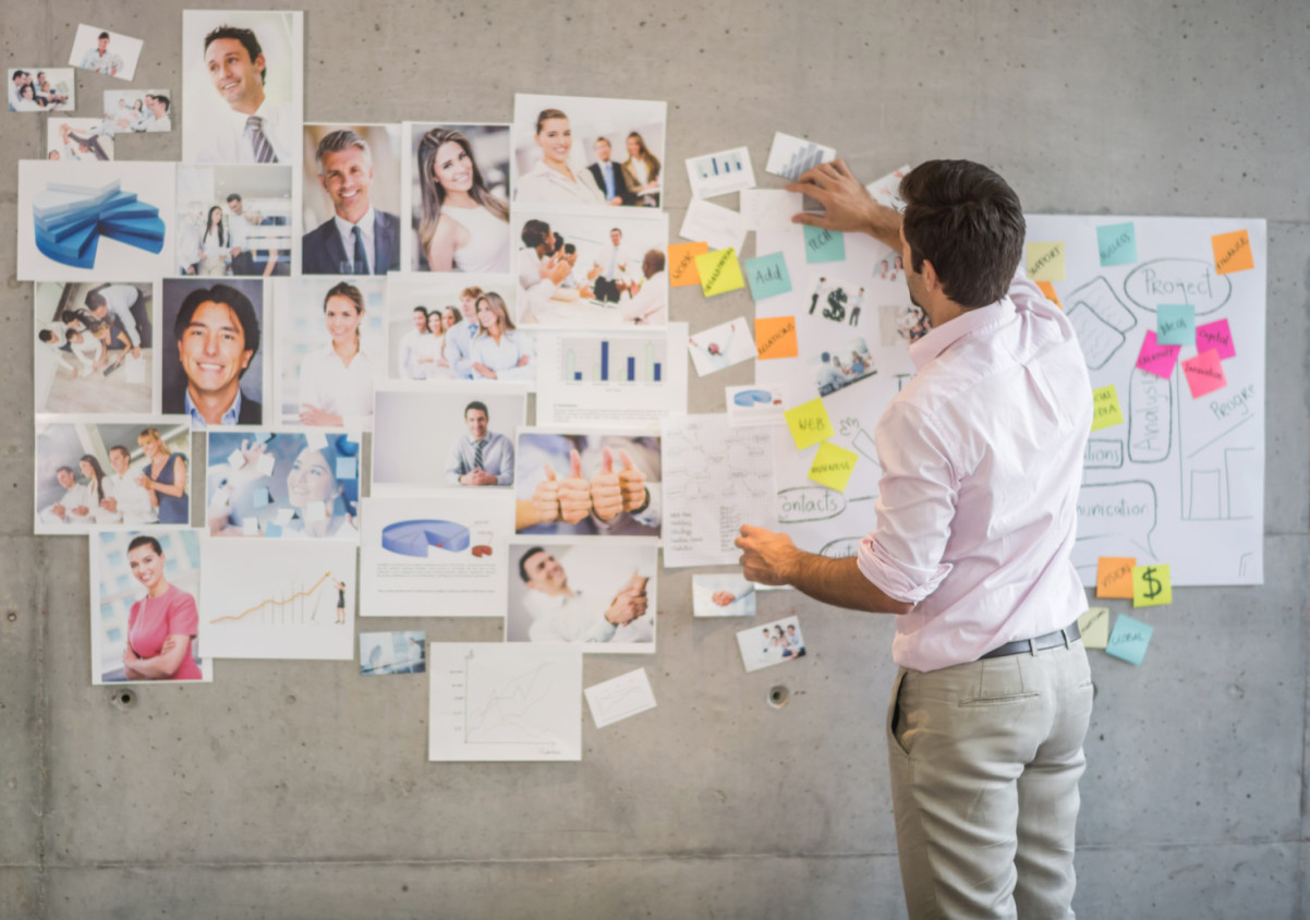 Creative business man creating a wall chart persona