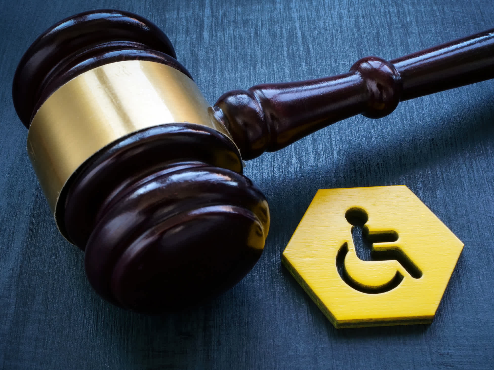A Gavel as a symbol of law and a disability person sign. | Watermark Agency