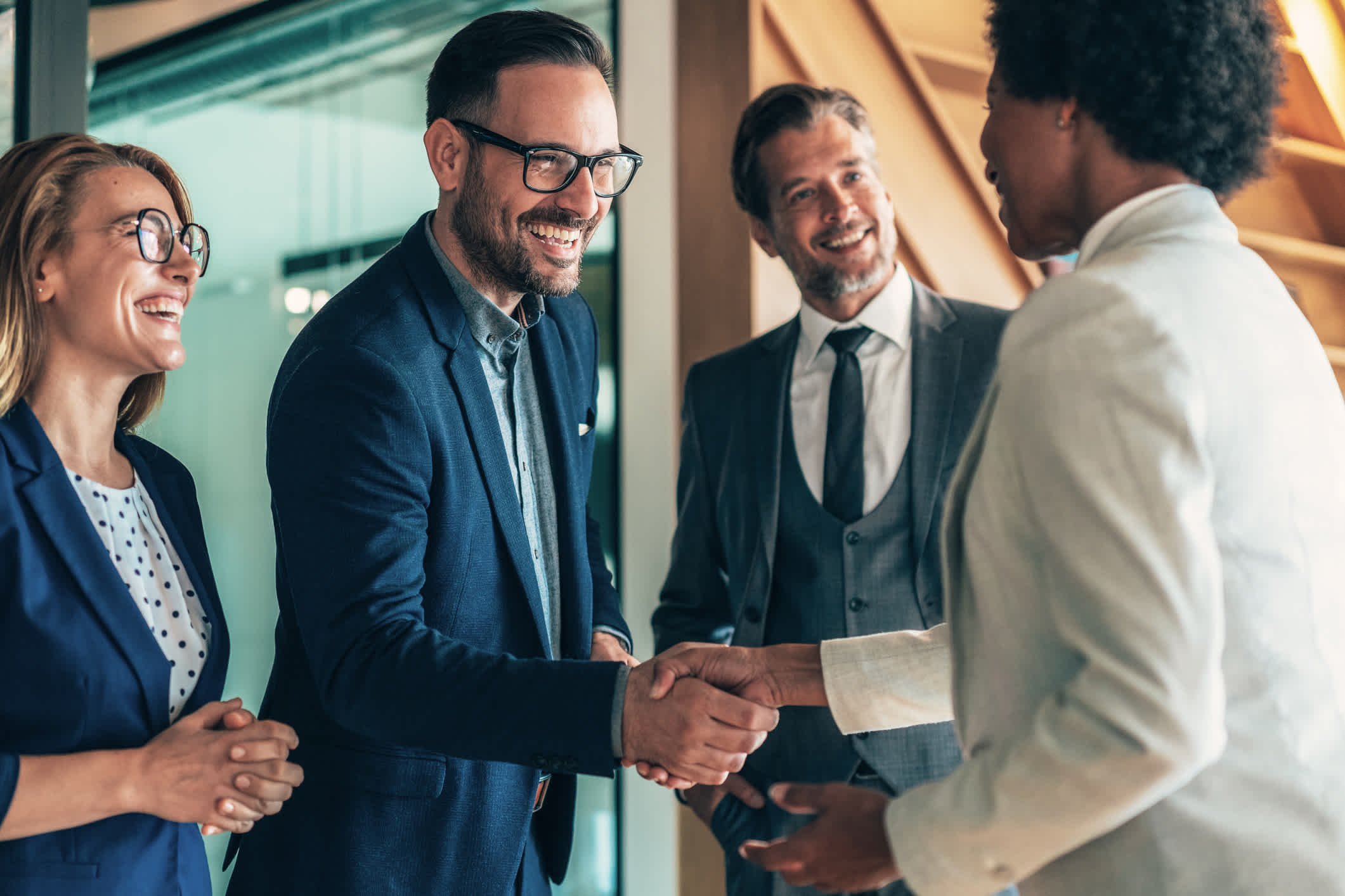 Group of business persons shaking hands in the office. Multi-ethnic business team, businessman and businesswoman shaking hands congratulating for outstanding work and success. Meet and Greet new colleagues in the group.| Watermark