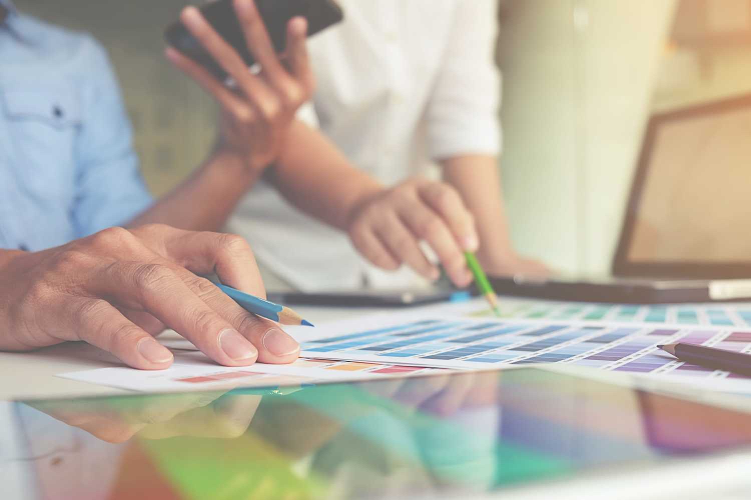graphic design and coloured swatches and pens on a desk
