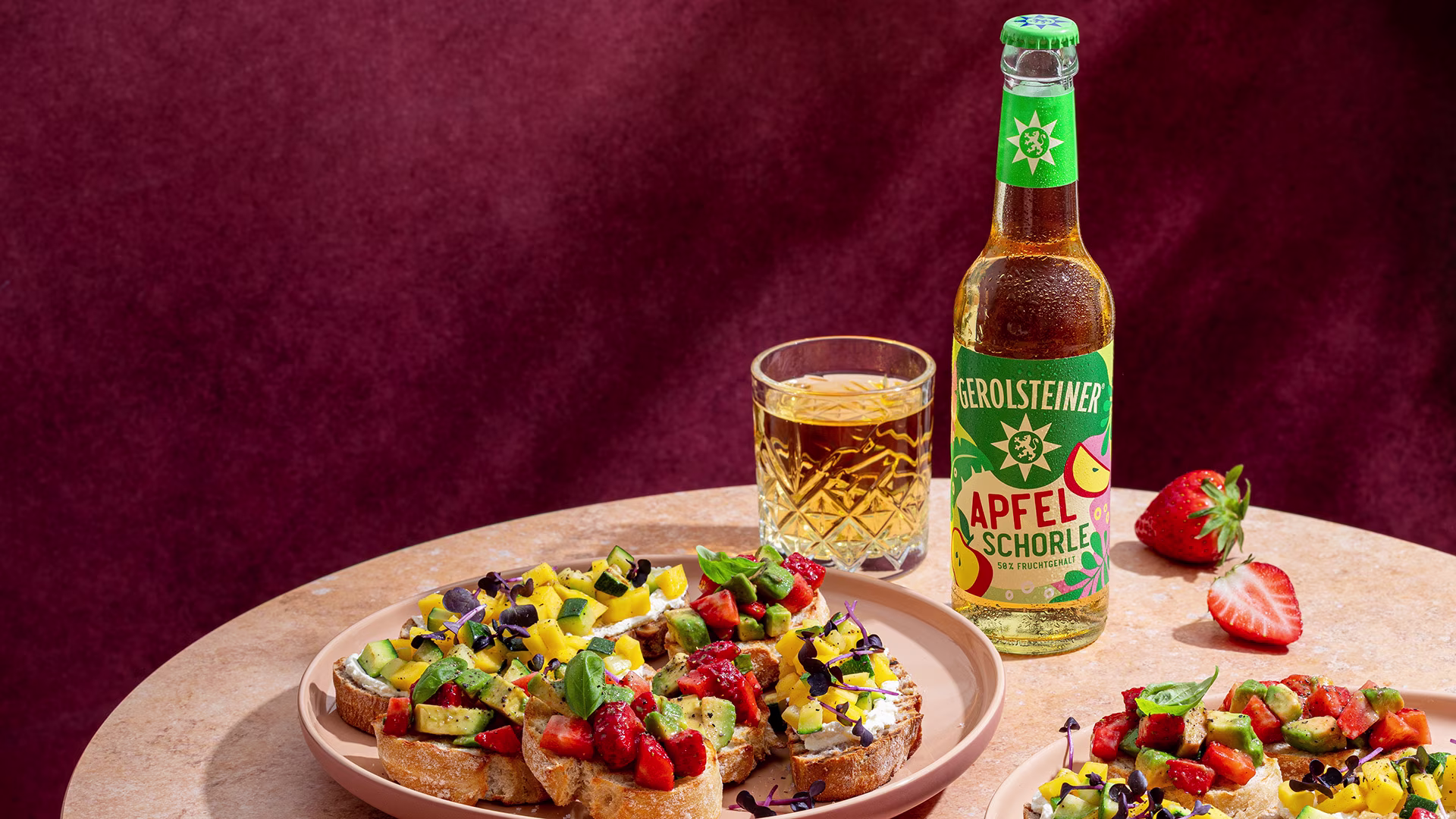 Knusprige Bruschetta-Variationen mit frischen Erdbeeren, Avocado und cremigem Topping auf geröstetem Brot. Dazu eine erfrischende Gerolsteiner Apfelschorle als fruchtige Begleitung.
