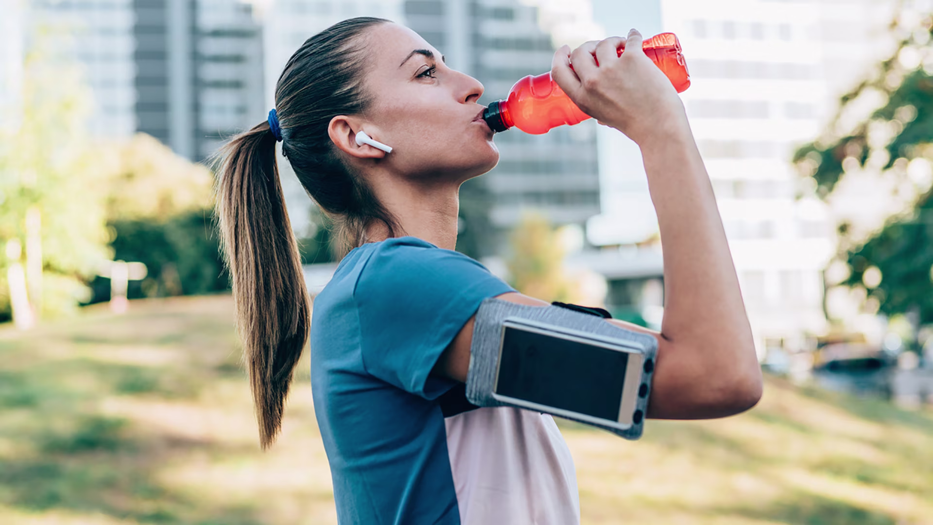 Frau trinkt Wasser nach dem Joggen