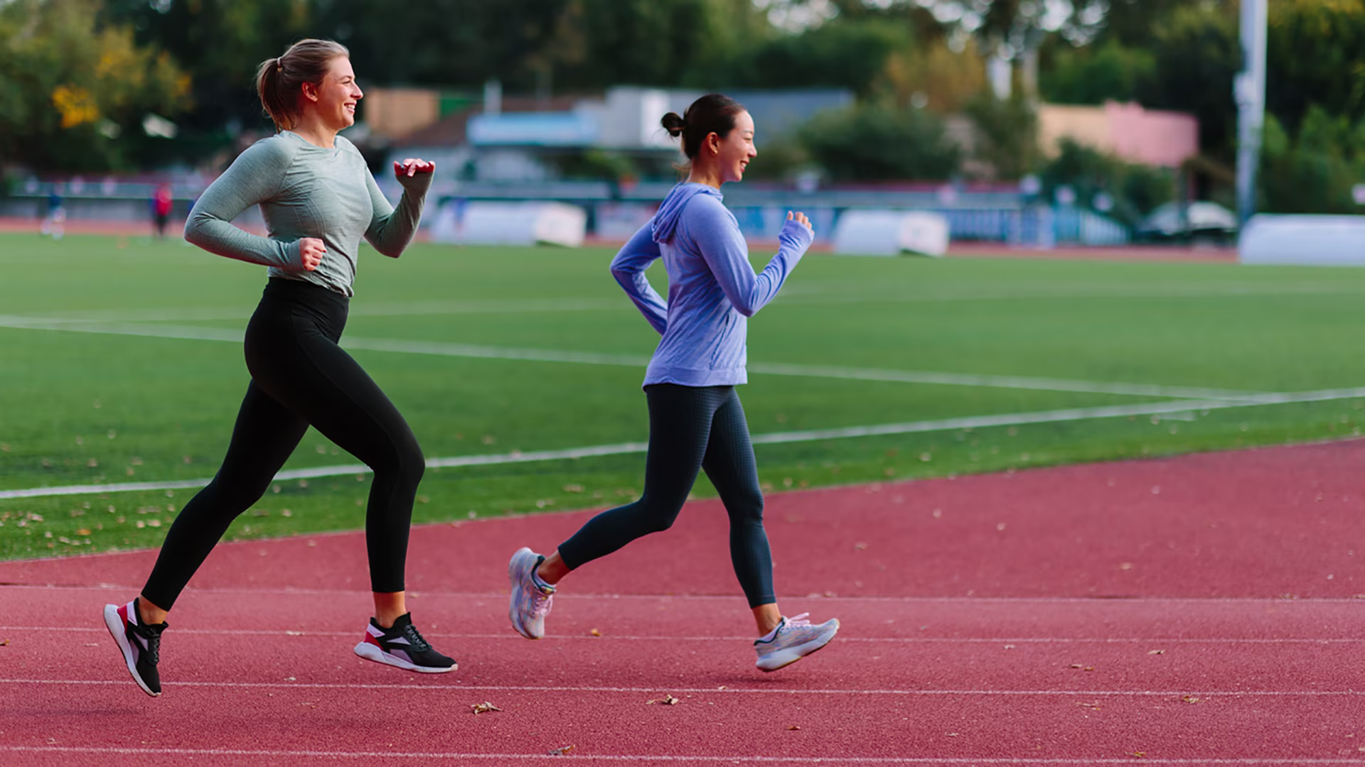 Zwei Frauen absolvieren ihr Cardio-Training auf der Laufbahn