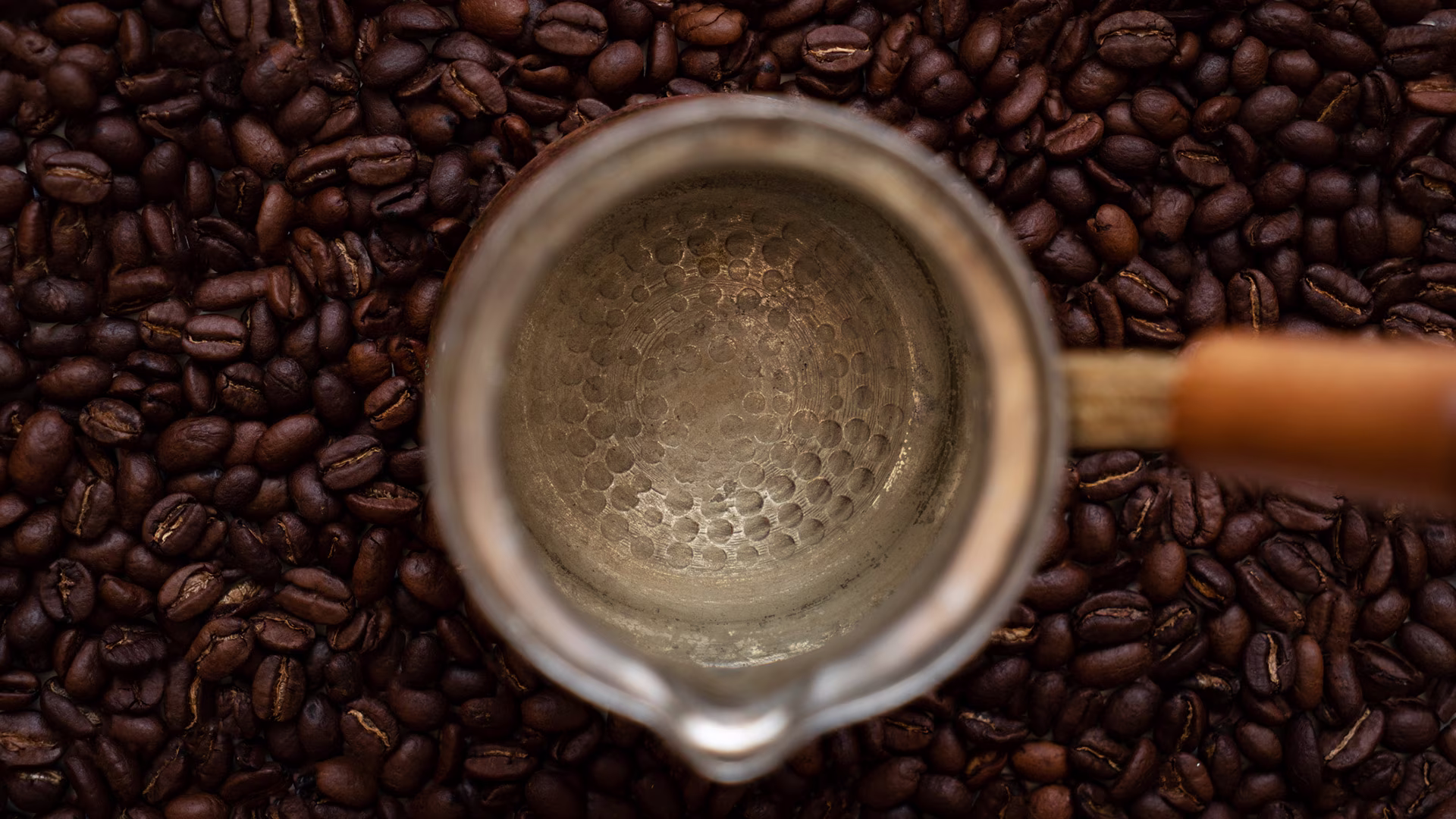 Frisch geröstete Kaffeebohnen mit Kaffeekanne, sichtbarer Röstprozess und Aroma: Authentisches Food-Foto zu Kaffee Bitterstoffe, Handröstung und hochwertigem Bohnenkaffee.