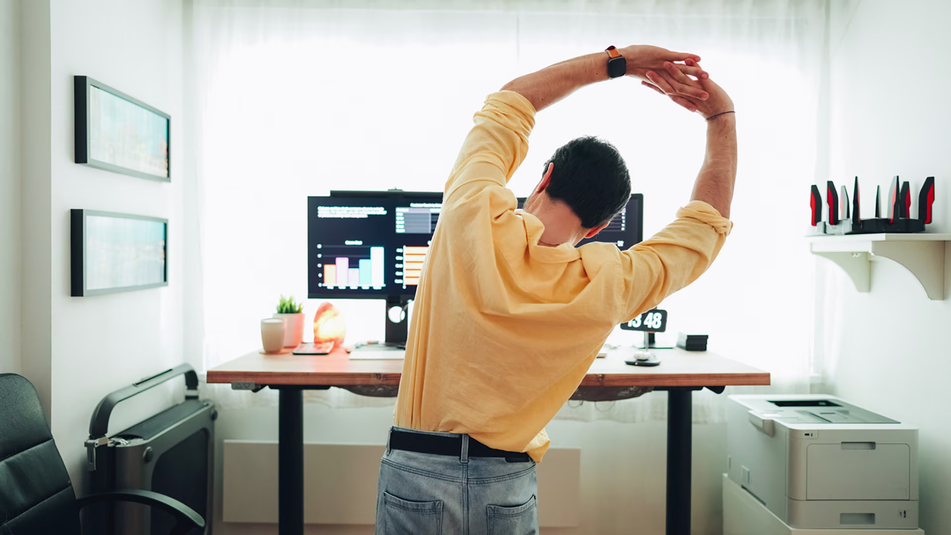 Person macht Dehnübung am Schreibtisch im Homeoffice – einfache Bewegung im Alltag während der Arbeit.