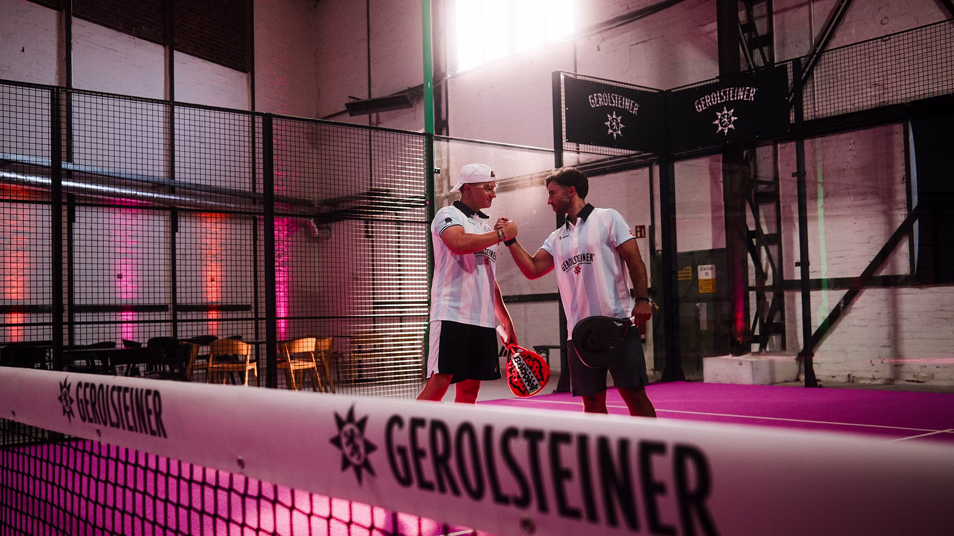 Zwei Padel-Spieler begrüßen sich auf dem Court beim Gerolsteiner Community Event.