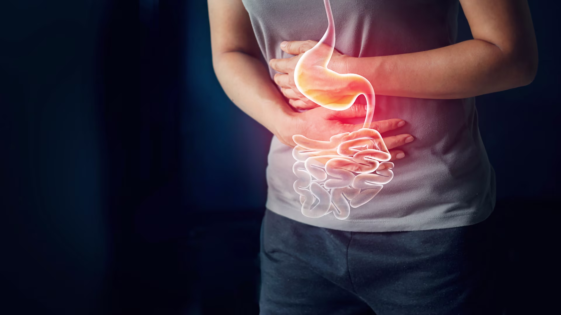 Person mit Bauchschmerzen, darüber eingeblendete Illustration von Magen und Darm.