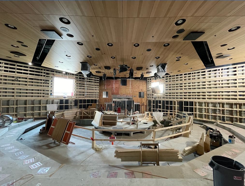 An image of the construction of the Elie Weisel Auditorium located in the Forum Building on the Obama Presidential Center campus. The picture features wood panels across the walls and on the ceilings. In the center of the floor are wood planks that will become the seating area of the auditorium.