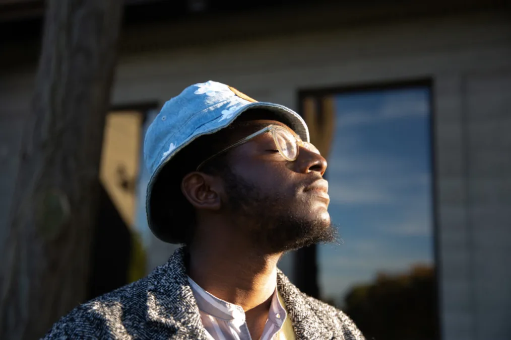 Community Leadership Corps participant Oluwaseyi Adeleke takes in the warming sun with his eyes closed.