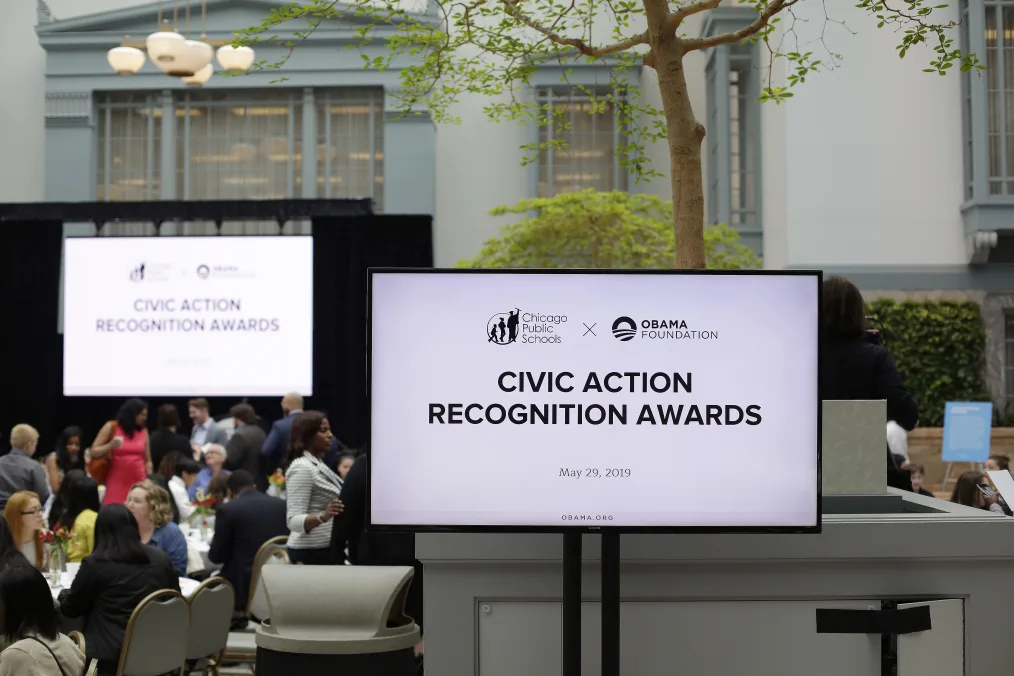 A large white screen reads "Chicago Public Schools x Obama Foundation" and the text below reads "Civic Action Recognition Awards"