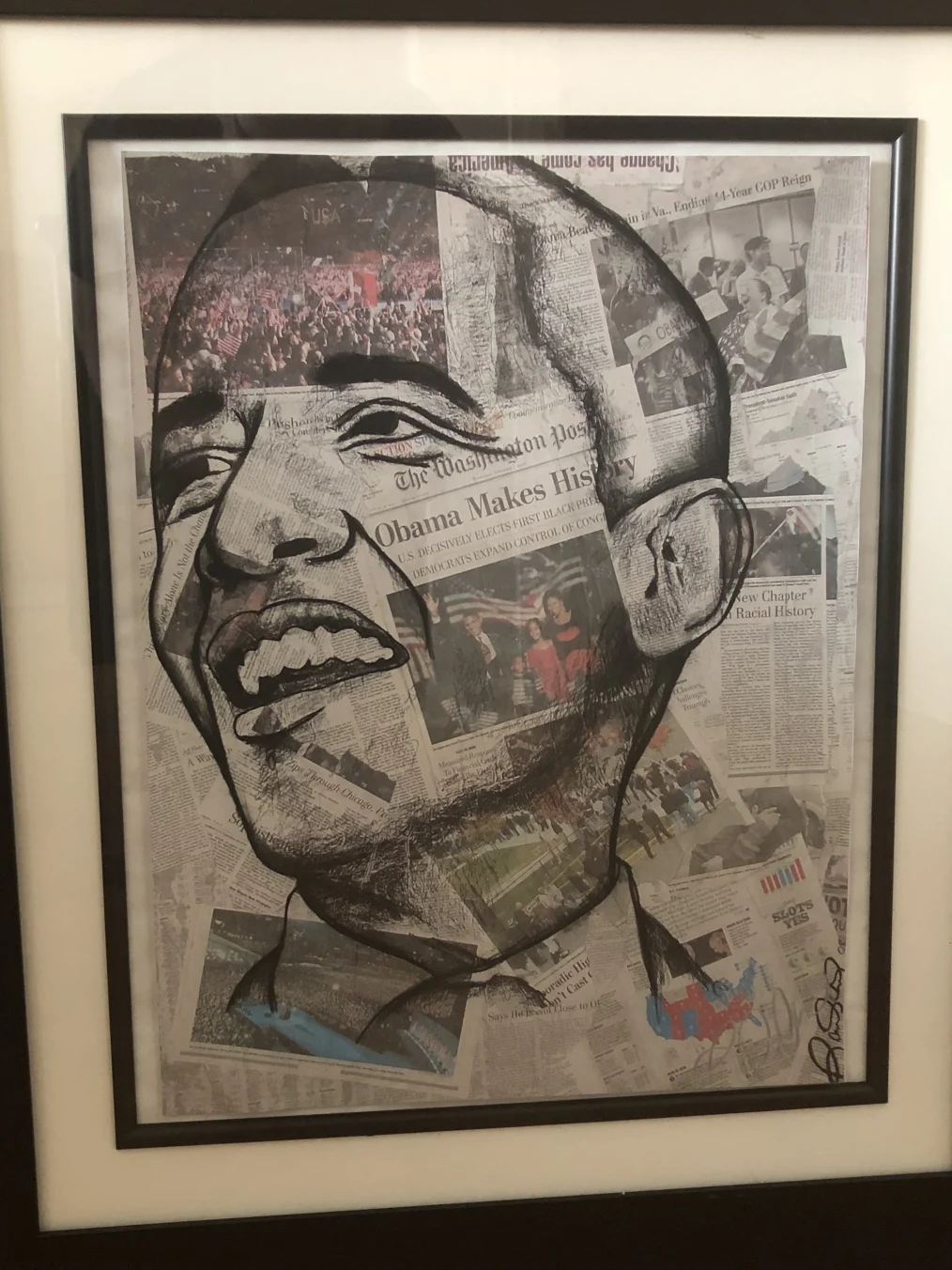 A framed collage of newspaper clippings about Barack Obama's presidential win with a portrait of his head drawn in black on top.