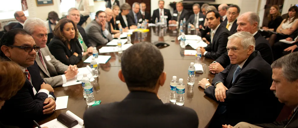 President Obama meets with a roundtable of people with various skin tones.