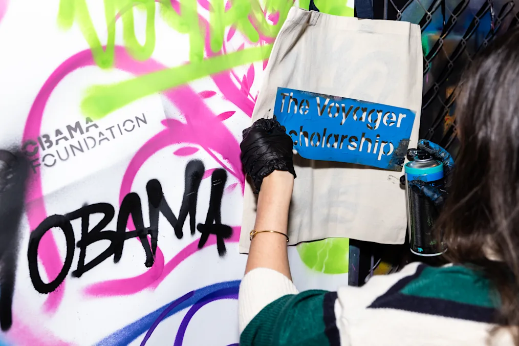 An airbrush mural features the words “Voyager Scholarship” and “Obama Foundation.” 