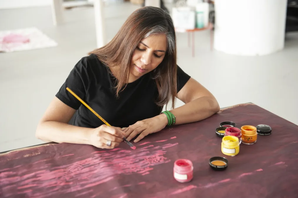 Pooja works on a piece of art in her studio