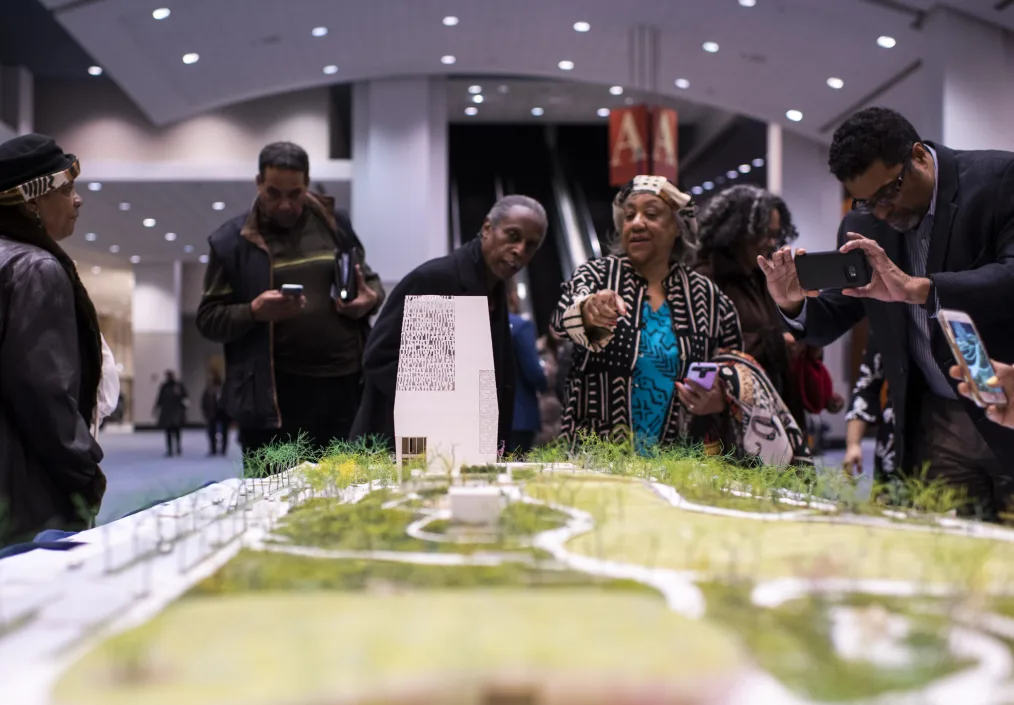 A group of Chicagoans look at the model of the Obama Presidential Center
