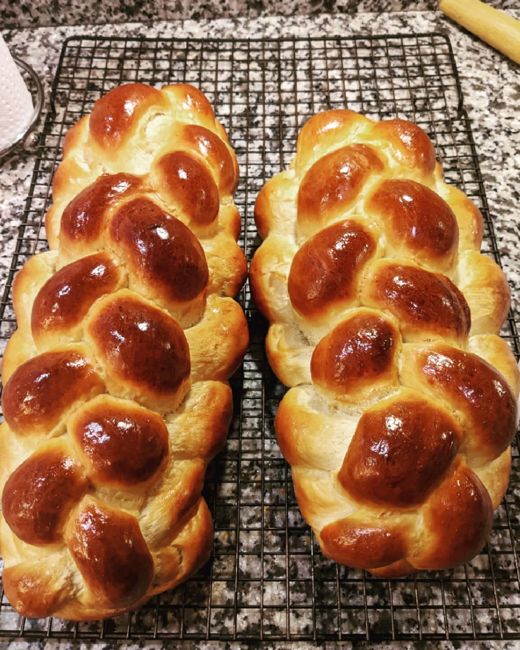 Two freshly baked loaves of challah bread.
