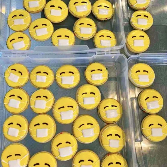 Dozens of cookies with the facemask emoji.