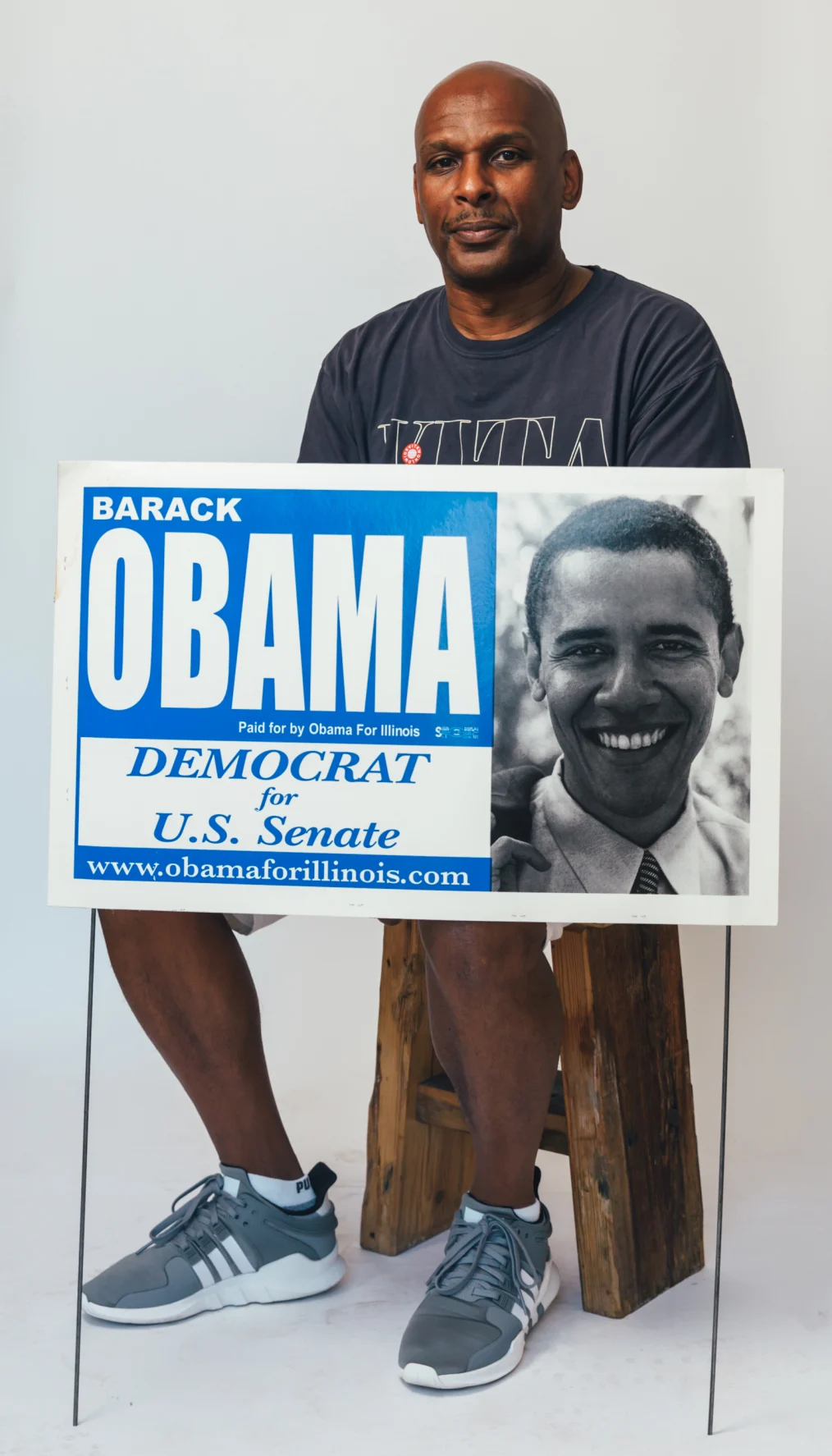 Lazerick Vaughen sits holding an election sign for then-Senator Barack Obama.