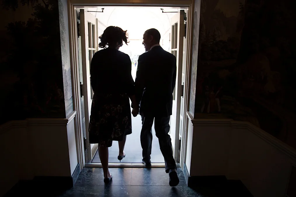 President and Mrs. Obama stand in a doorway at the White House.
Alt text: President and Mrs. Obama hold hands as they walk from the Diplomatic Reception Room of the White House to Marine One for departure en route to Fort Hood, Texas, April 9, 2014. Their backs are to the camera. (Official White House Photo by Chuck Kennedy) 
