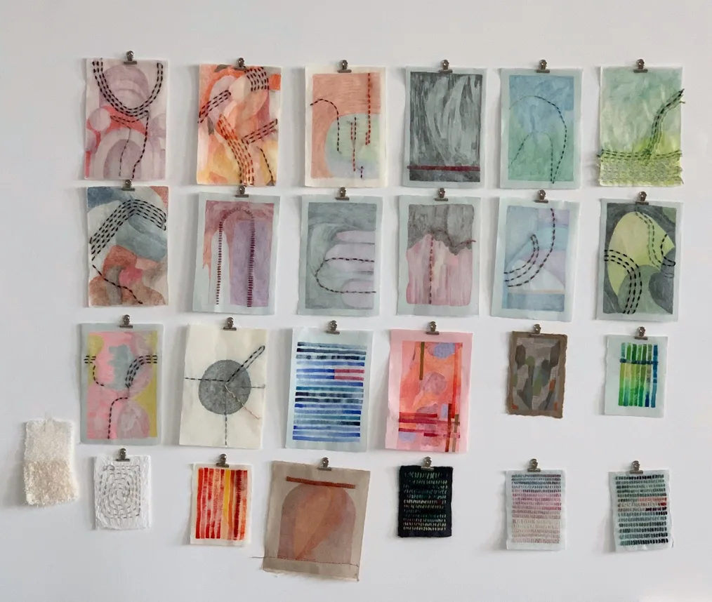 Drawings of all sizes hung on a wall.