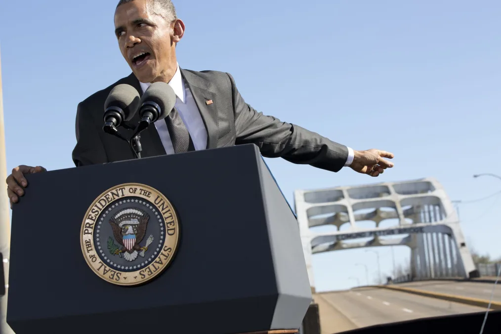 

President Obama gives a passionate speech over a podium in the middle of the street 
