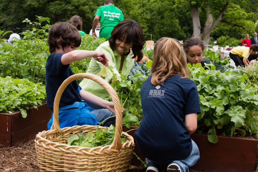 First Lady Michelle Obama harvests vegetables with students