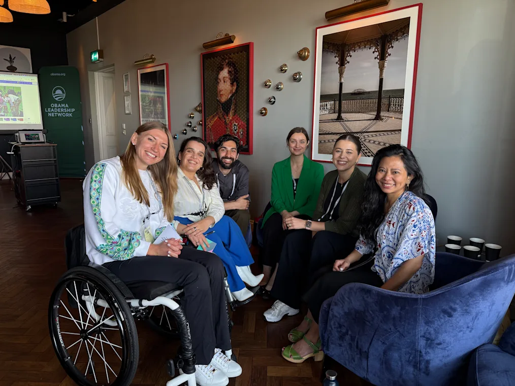 Vladyslava Kravchenko, a woman with a light skin tone and blonde hair, sits in a wheelchair as she poses with five others. They all have light skin tones and dark hair.