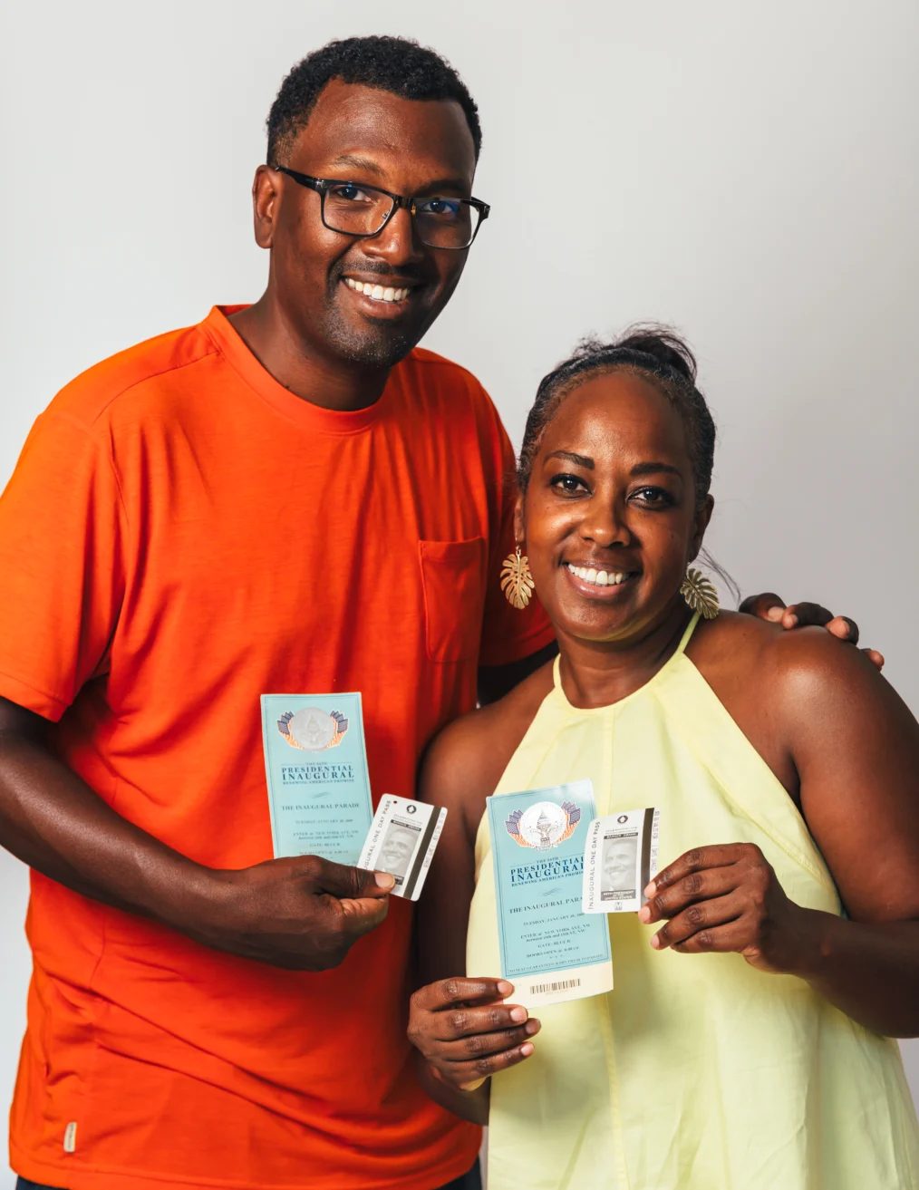 Ghian Foreman and his daughter smile and embrace, holding their metro passes to President Obama's inauguration.