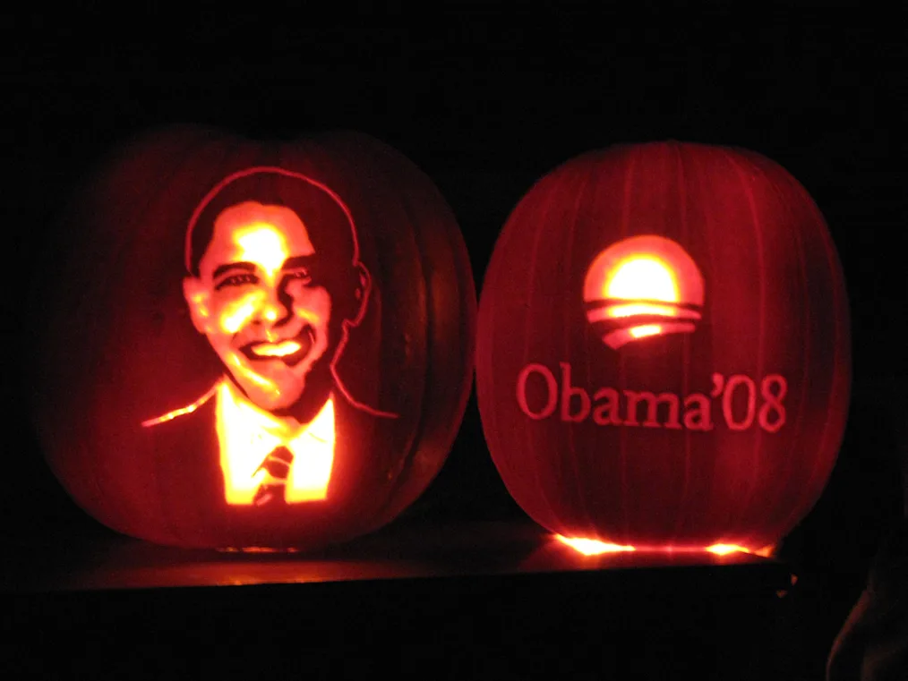 Two pumpkins feature Barack Obama’s face to the left and the rising sun logo to the right. The pumpkin on the right reads, “Obama ‘08.” Both are glowing.