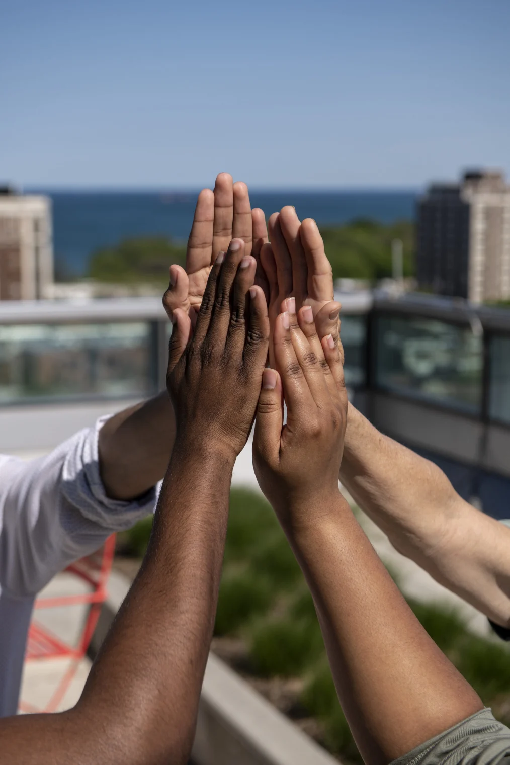 Four hands demonstrate the shape of the Obama Presidential Center tower against the Chicago skyline.