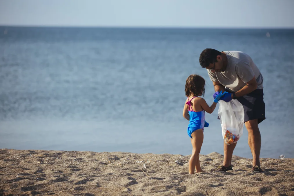 A father and daughter share a quiet moment during participate in a sunset cleanup of Rainbow Beach in Chicago.