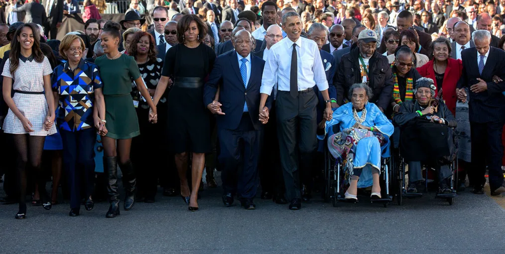 President Barack Obama and First Lady Michelle Obama join hands with Rep. John Lewis