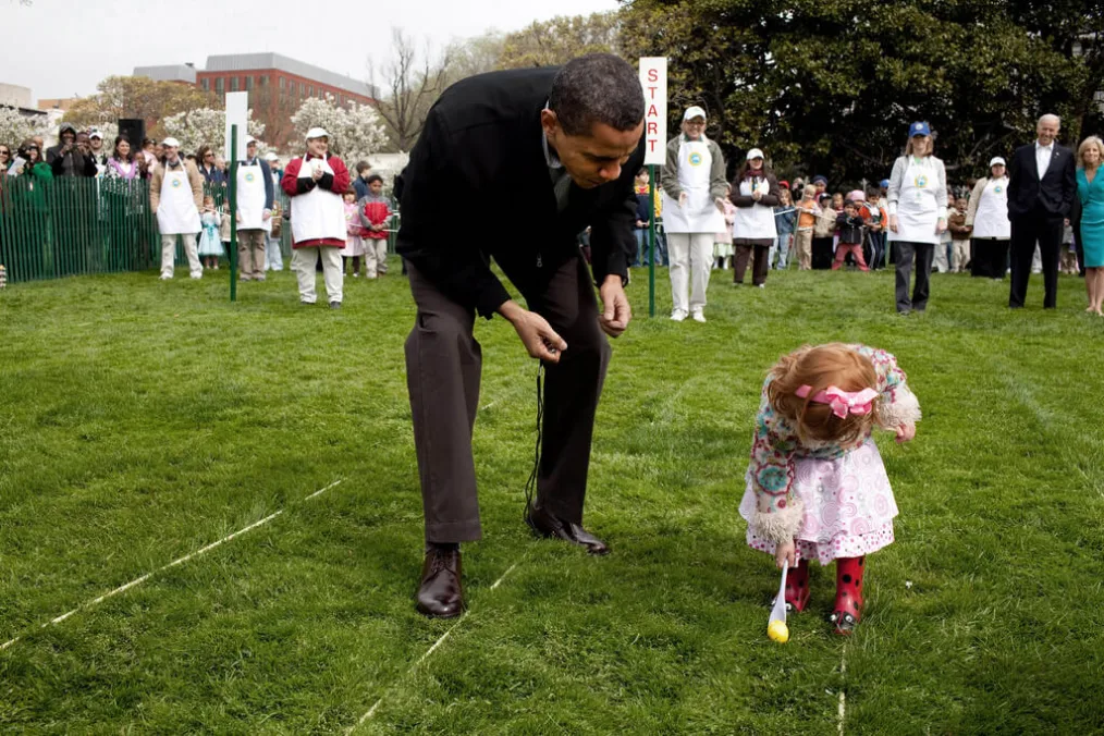 President Obama helps a little girl in a egg race during a public event.
