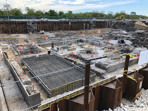 A wide view of a construction site with metal pilings and rebar.