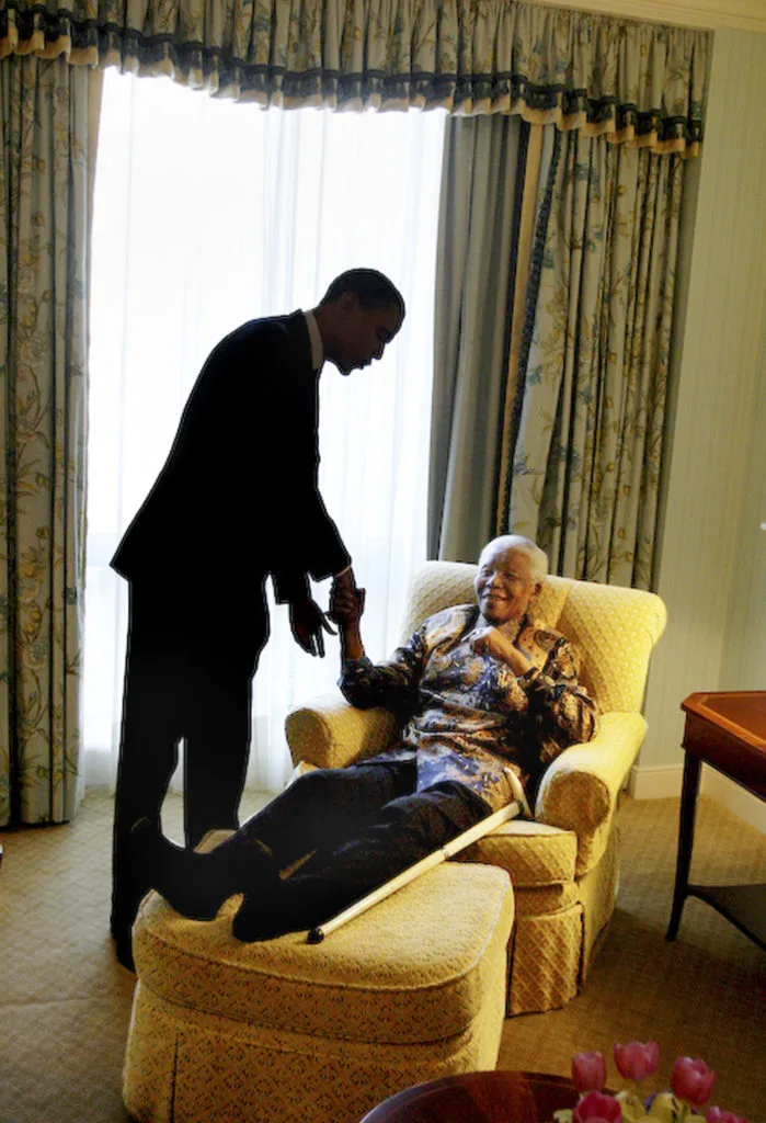 President Obama holds the hand of a elderly woman with a medium deep skin toned. She lays on a bright yellow couch with her legs out in front of her.