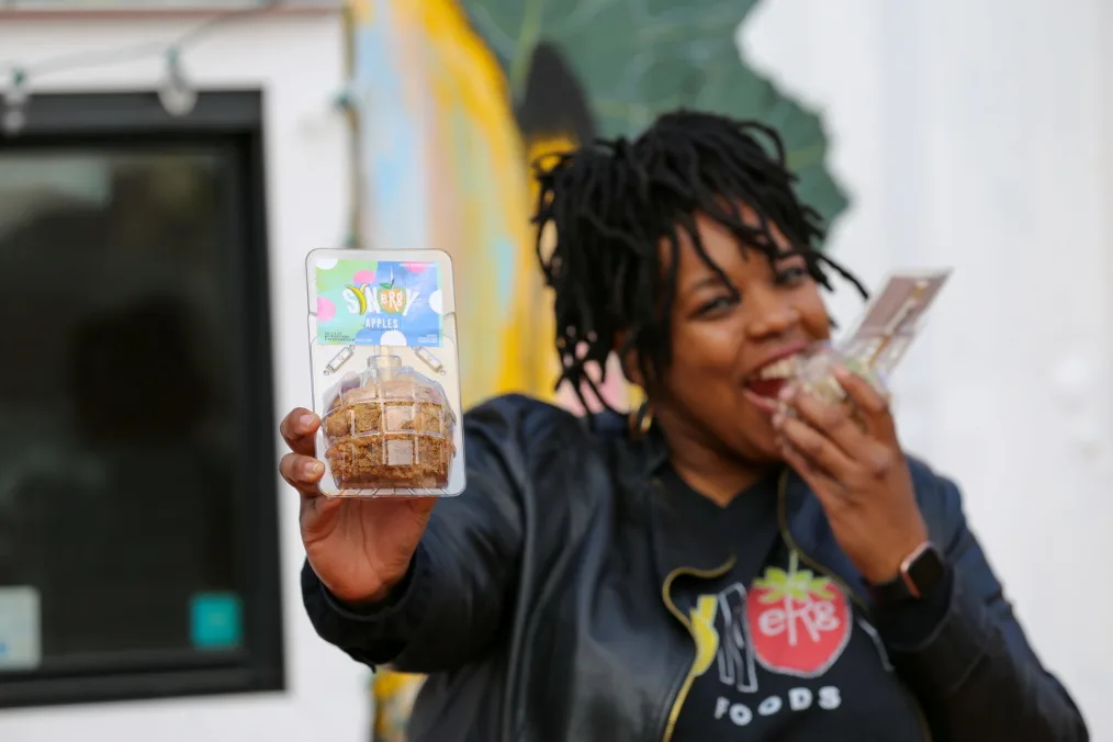 Leah Holmes holds a caramel apple to camera.