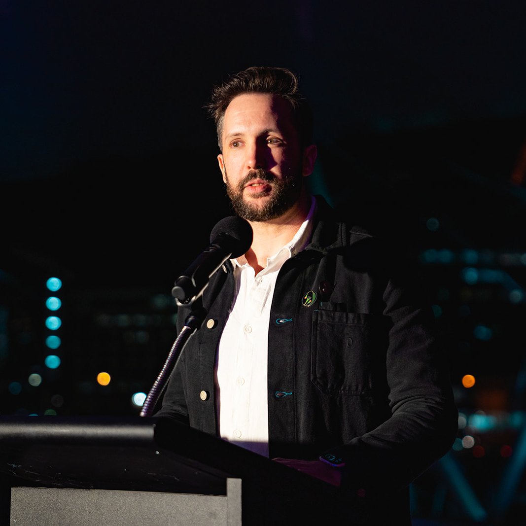 William Smith Stubbs, a man with a light skin tone, speaks behind a podium at the launch of MoSS at the Queensland Gallery of Modern Art. 