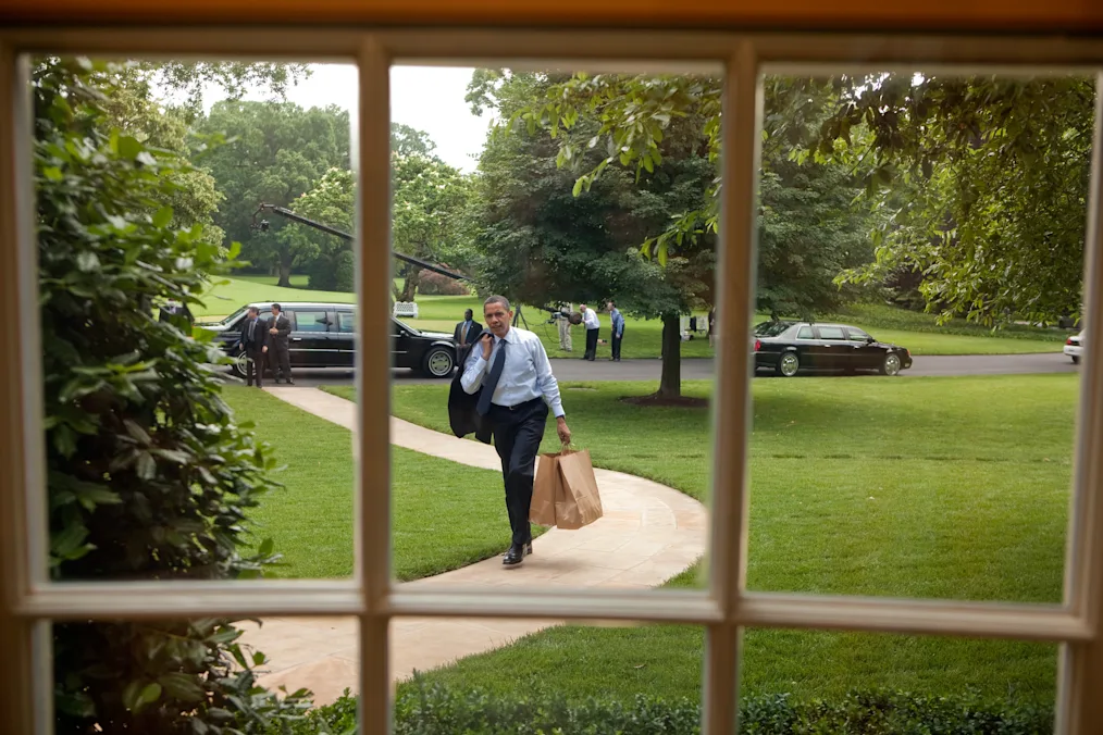 President Obama returns to the Oval Office holding brown paper bags after going on a hamburger run for West Wing staffers and aides, May 29, 2009. (Official White House Photo by Chuck Kennedy)
