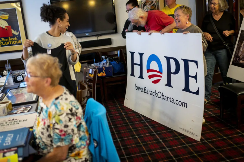 Louise Bernard reacts as supporters of President Obama's campaigns hold up a poster that reads "Hope."