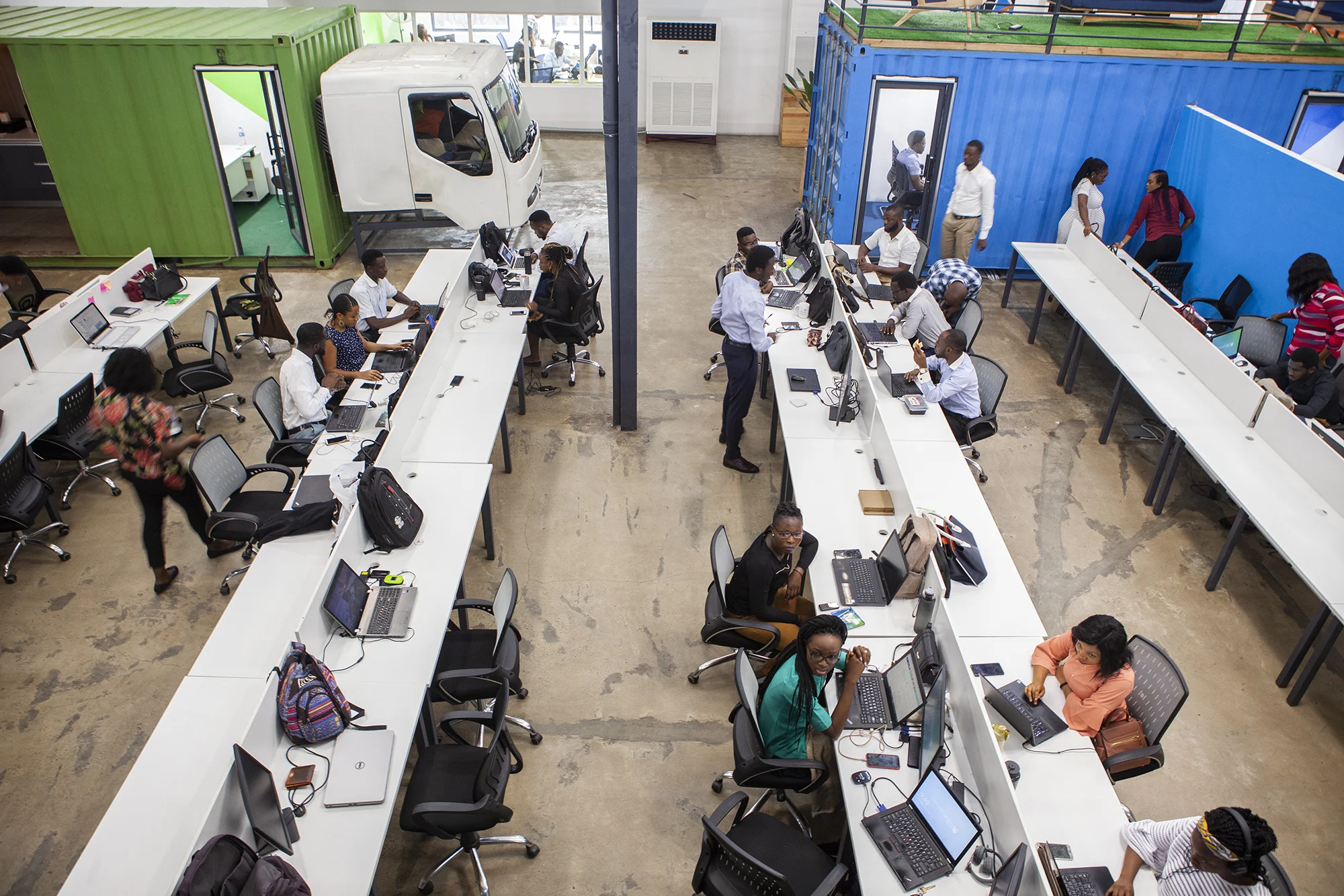 A diverse group of people with medium brown skin sitting at computers