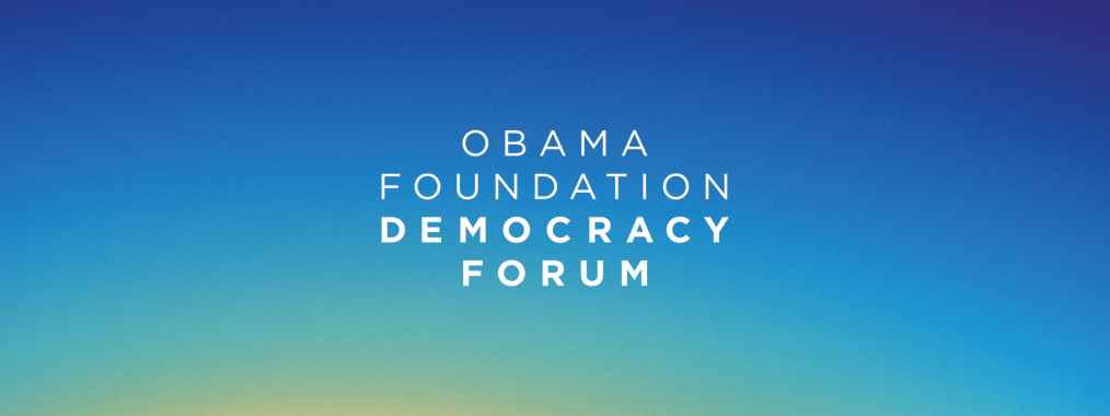 White text that reads "Obama Foundation Democracy Forum" on a mostly blue sunset background. 