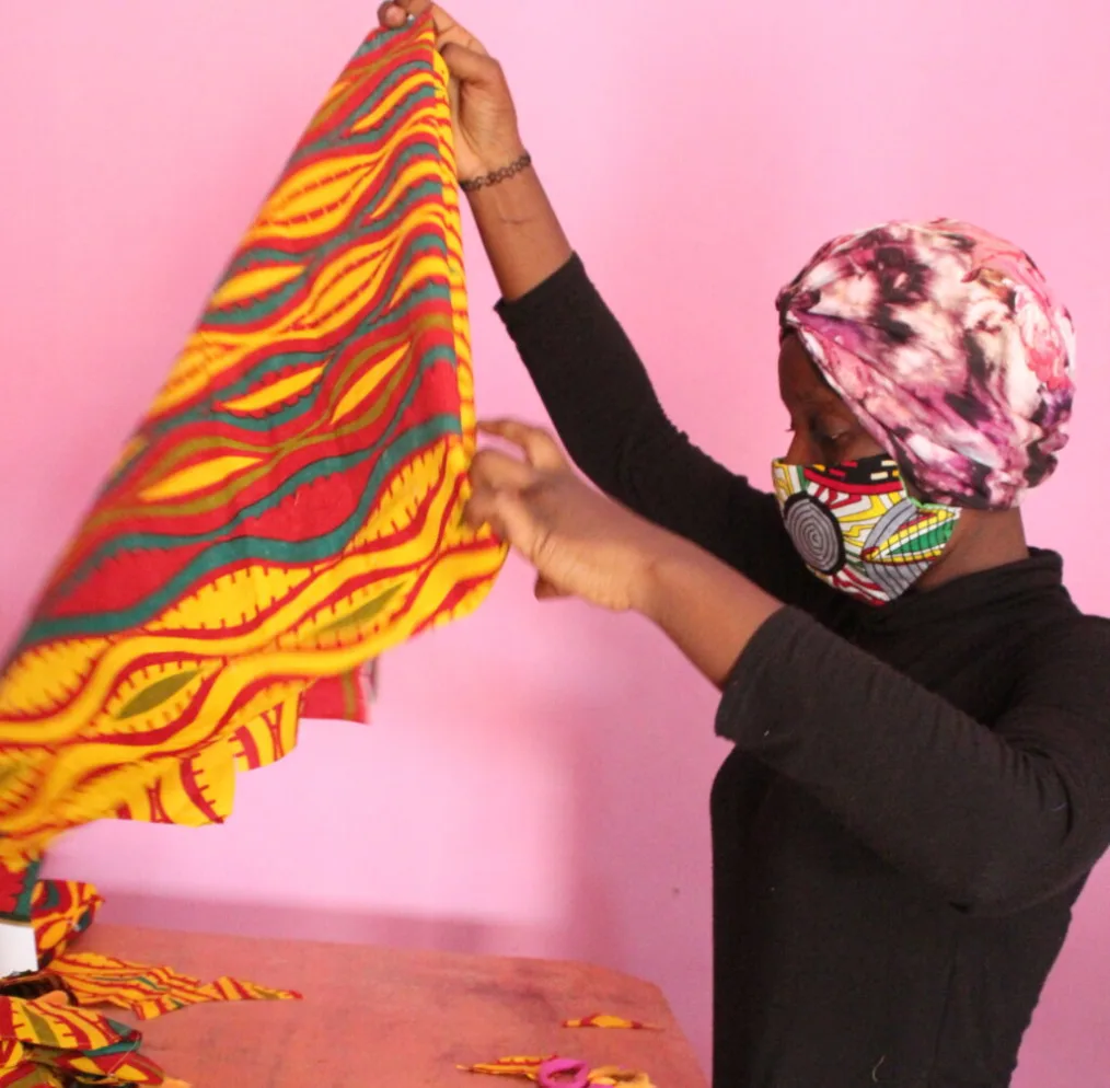 A woman holds up a patterned piece of cloth.
